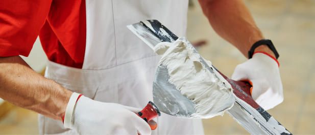 Eine Person trägt Spachtelmasse auf